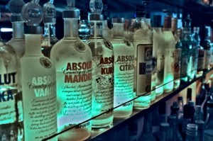 Bouteilles de vodka sur une étagère éclairée en bleu dans un bar